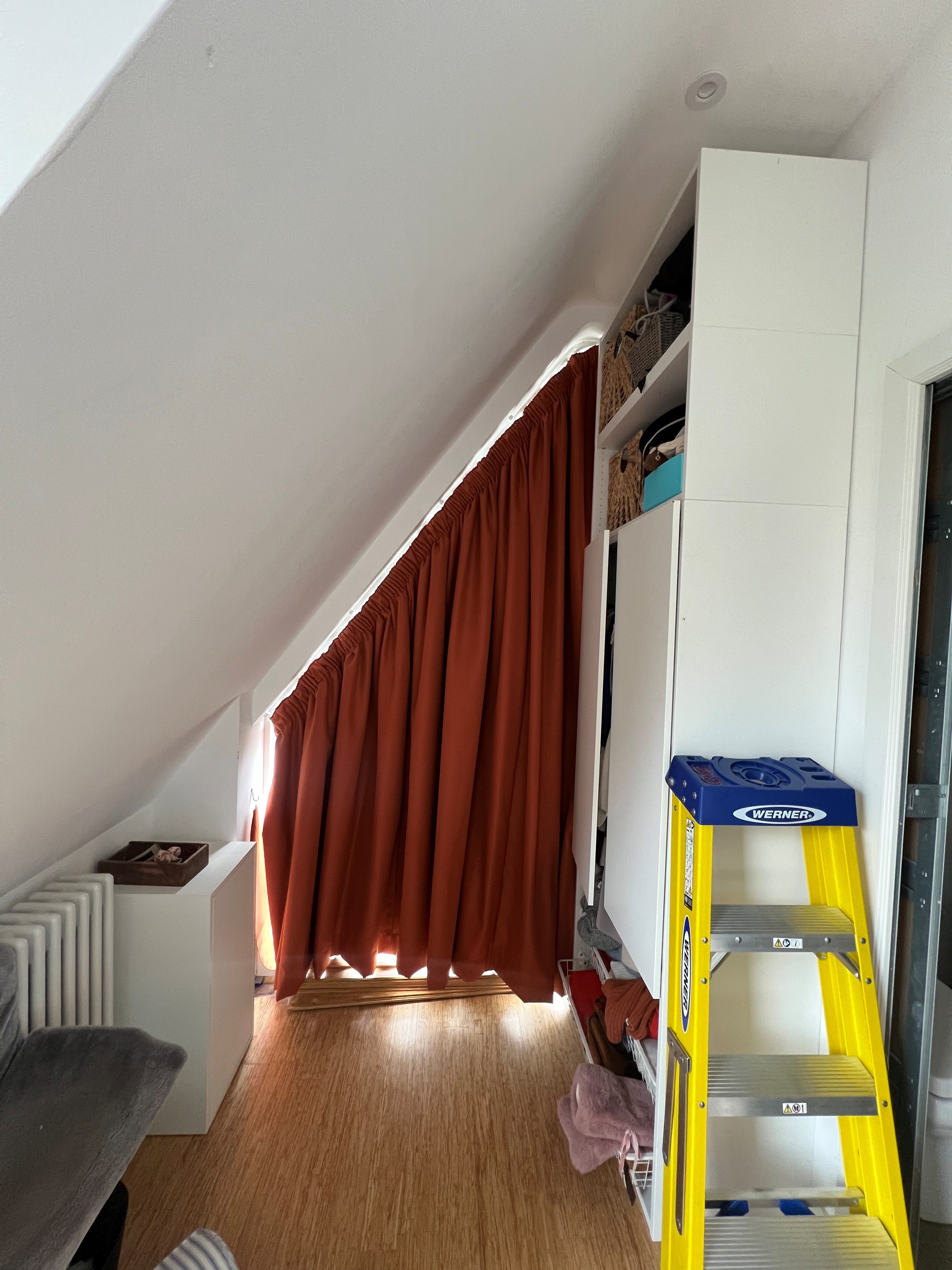 Gable end loft window with a shaped curtain fully covering the sloped glass