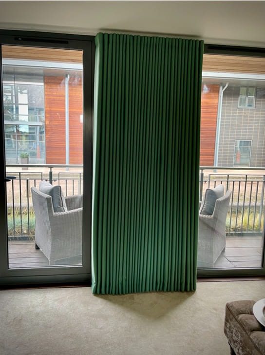 Mimas acoustic curtain free-standing room divider on an apartment balcony